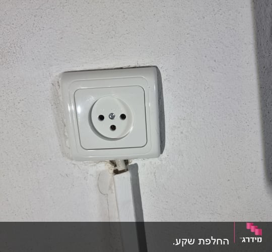 שקע חשמל מותקן על קיר לבן